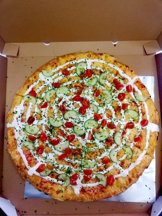 Pizza z ogórkiem, pomidorkami cherry, szczypiorkiem i białym sosem w pudełku