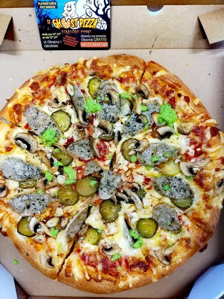 Pizza z kiełbasą, ogórkami kiszonymi, pieczarkami i zielonym sosem w pudełku z ulotką Ghost Pizza