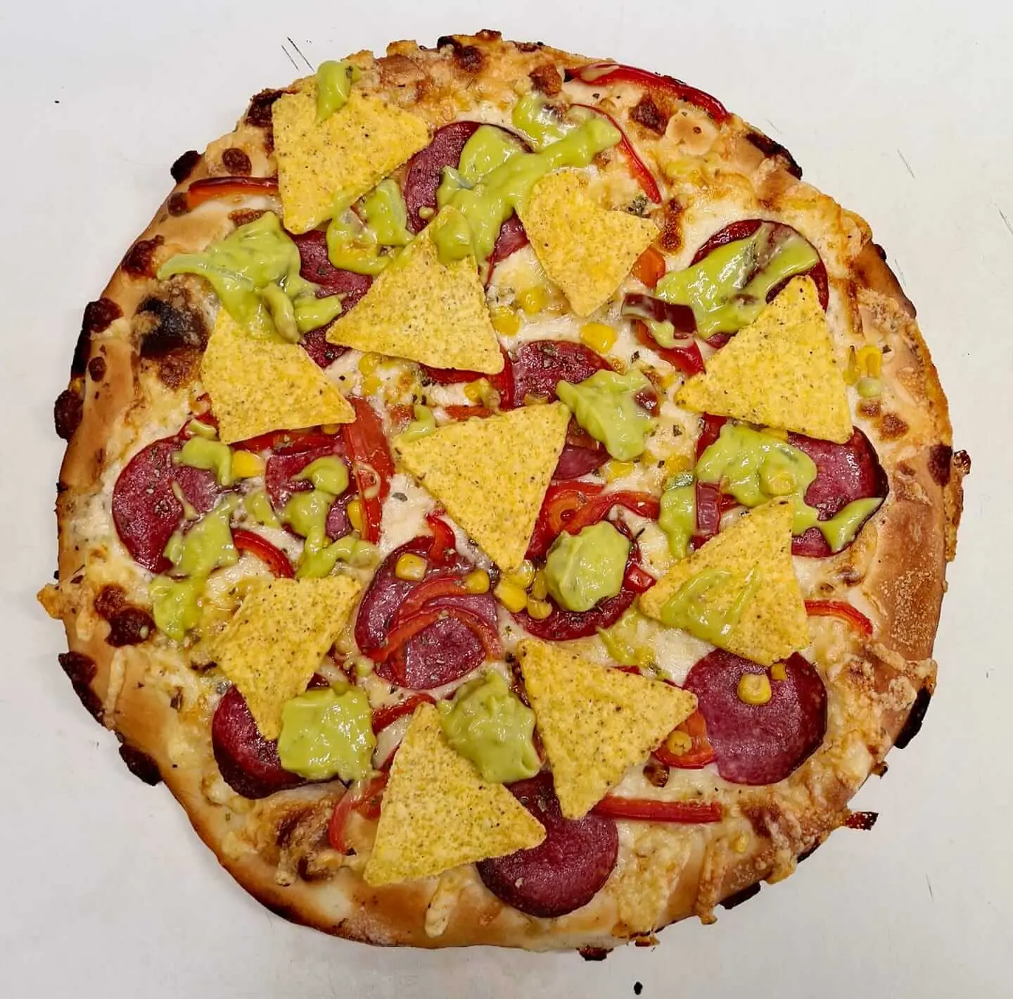 Pizza z salami, papryką, kukurydzą, nachosami i sosem guacamole