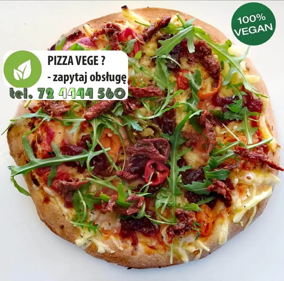 Wegańska pizza z rukolą i suszonymi pomidorami z napisem: Pizza vege? Zapytaj obsługę, tel. 72 4444 560